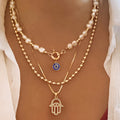 Nadia – Mehrreihige Perlenhalskette mit Hamsa-Hand