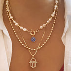 Nadia – Mehrreihige Perlenhalskette mit Hamsa-Hand